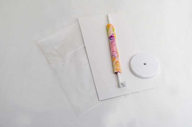 タペストリー(塩ビパイプ入)、スタンドポール、土台を白台紙と共に袋入れ