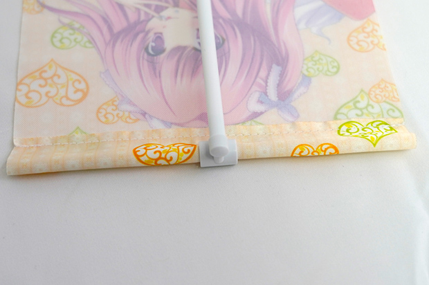 タペストリー上部をスタンドポールの上に挟みます